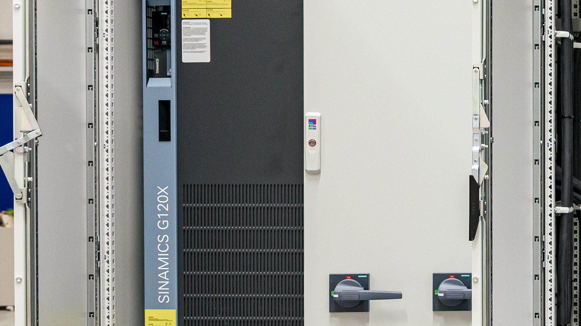 Industrielle Schaltanlage mit SINAMICS G120X Frequenzumrichter und Bedienfeld in grauem Schaltschrank