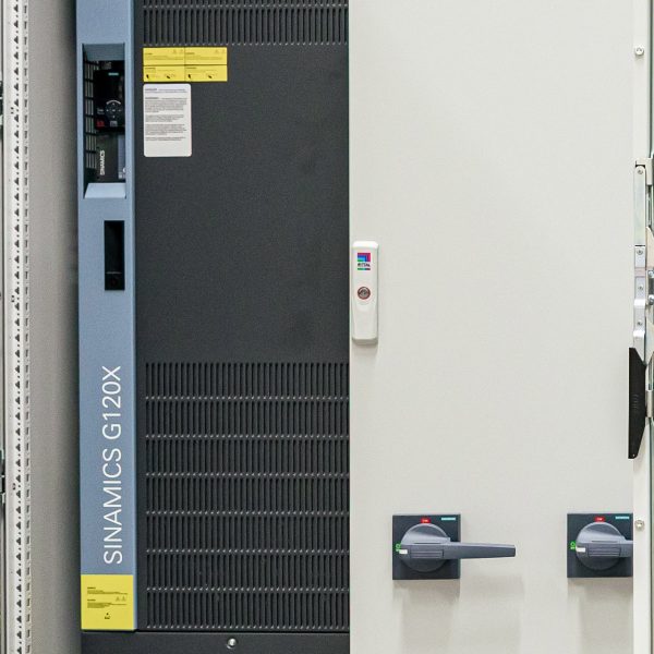Industrielle Schaltanlage mit SINAMICS G120X Frequenzumrichter und Bedienfeld in grauem Schaltschrank