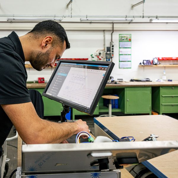 Techniker arbeitet an Retrofit-Projekt mit Computer und elektronischen Komponenten in moderner Werkstatt